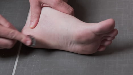 man removing corn, callus from his feet using a razor file, masculine skin care, skin disease, fungal infection, skin treatment