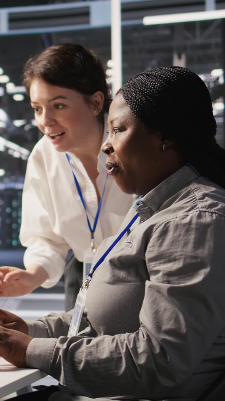 Vertical video Cheerful data center technicians collaborating on AI automation deployment