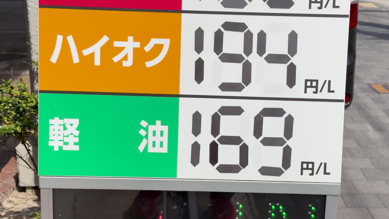 Panoramica ravvicinata su un'insegna di una stazione di servizio giapponese che mostra i prezzi attuali del carburante