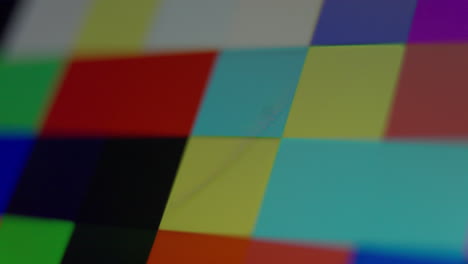 close up shot of a multi colored digital pixels flashing on a screen in a random, chaotic pattern