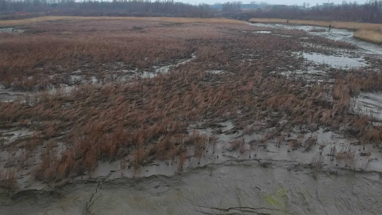 adelante aéreo sobre barro lecho de río seco campo paisaje fangoso día nublado
