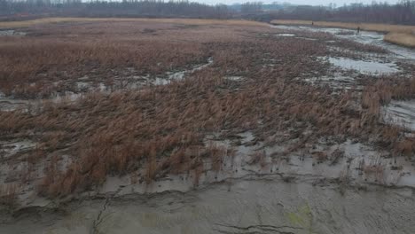 Luftaufnahme-über-Schlammigem,-Trockenem-Flussbettfeld,-Schlammige-Landschaft,-Bewölkter-Tag