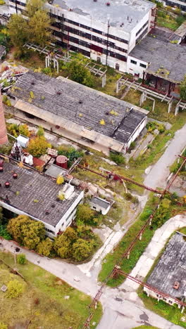 old industrial area. abandoned buildings with old roofs. destructive architecture of old factory. aerial view.. vertical video