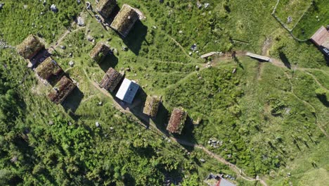 raksetra loen nordfjord - aerial top-down view showing cottages with grass covered rooftops and unrecognizable persons walking - norway