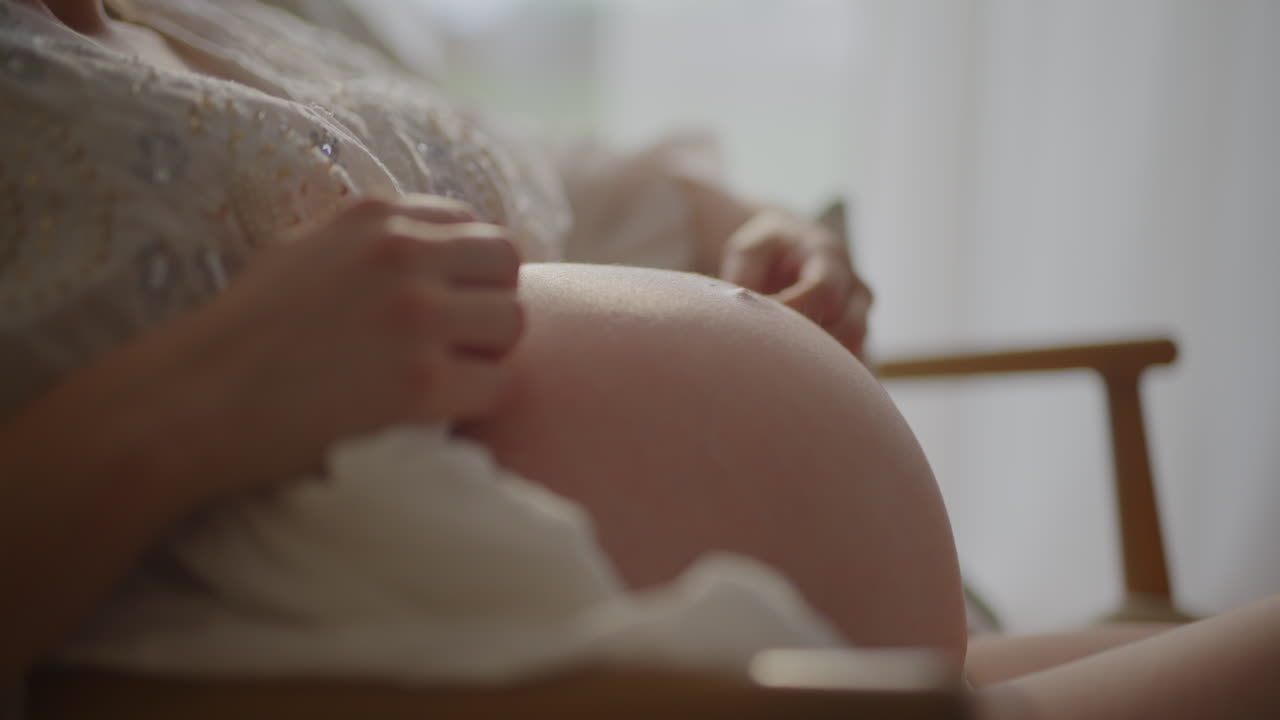 Pregnant Woman Embracing Baby Bump Close-up