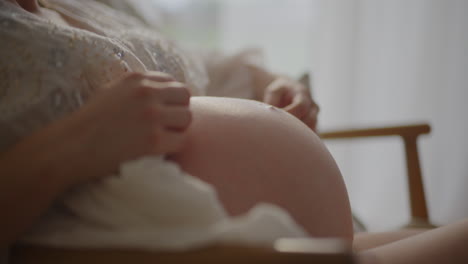 pregnant woman embracing baby bump close-up