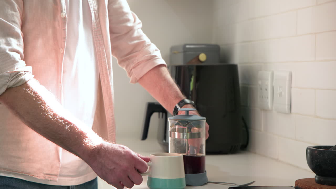 Senior man enjoying morning coffee at home, feeling relaxed and content