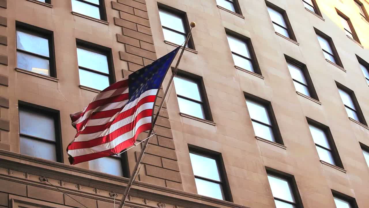 la bandera americana ondea desde un edificio en wall street en la ciudad de nueva york