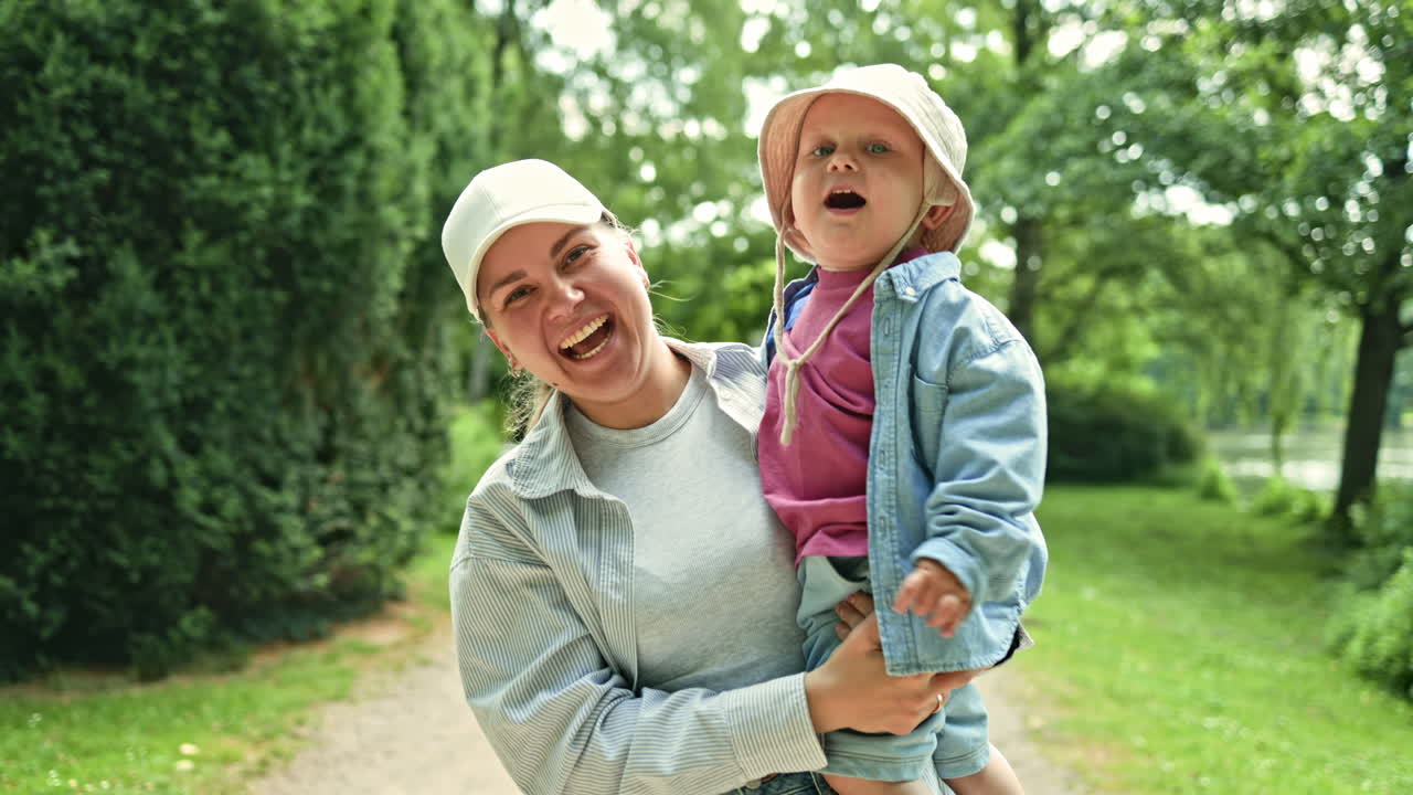 Glad mor med lille søn leger og løber i bypark. Mor og søn på gåtur i den friske luft. Konceptet om et lykkeligt forhold mellem mor og søn. Børneudvikling. Glad tumling