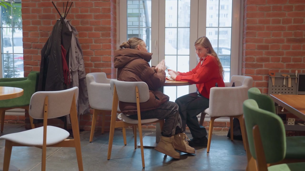 To venner møtes for samtale og klem på en kafé