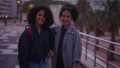 retrato hermosas hermanas gemelas hispanas riendo disfrutando de las vacaciones de verano juntas hermanos felices abrazándose buscando alegre cámara lenta