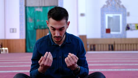 man raising his hands and praying in a mosque