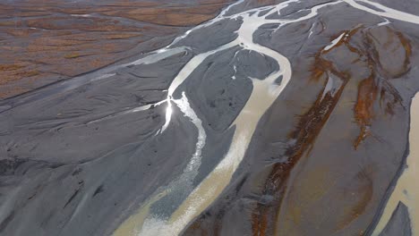 turbid river confluence in wet muddy plain with silt and gravel