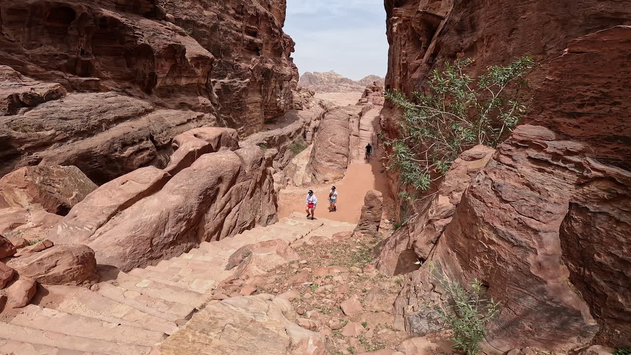 People rise by the stone stairs among the beautiful rocks. Travel by the Canyons of Sinai Desert in Jordan, West Asia.
