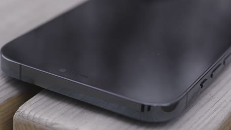 close-up of a black smartphone on a wooden surface