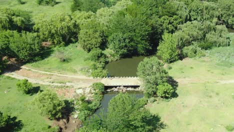 Drone-aerial-zoom-in-and-out-of-a-small-bridge-over-a-river