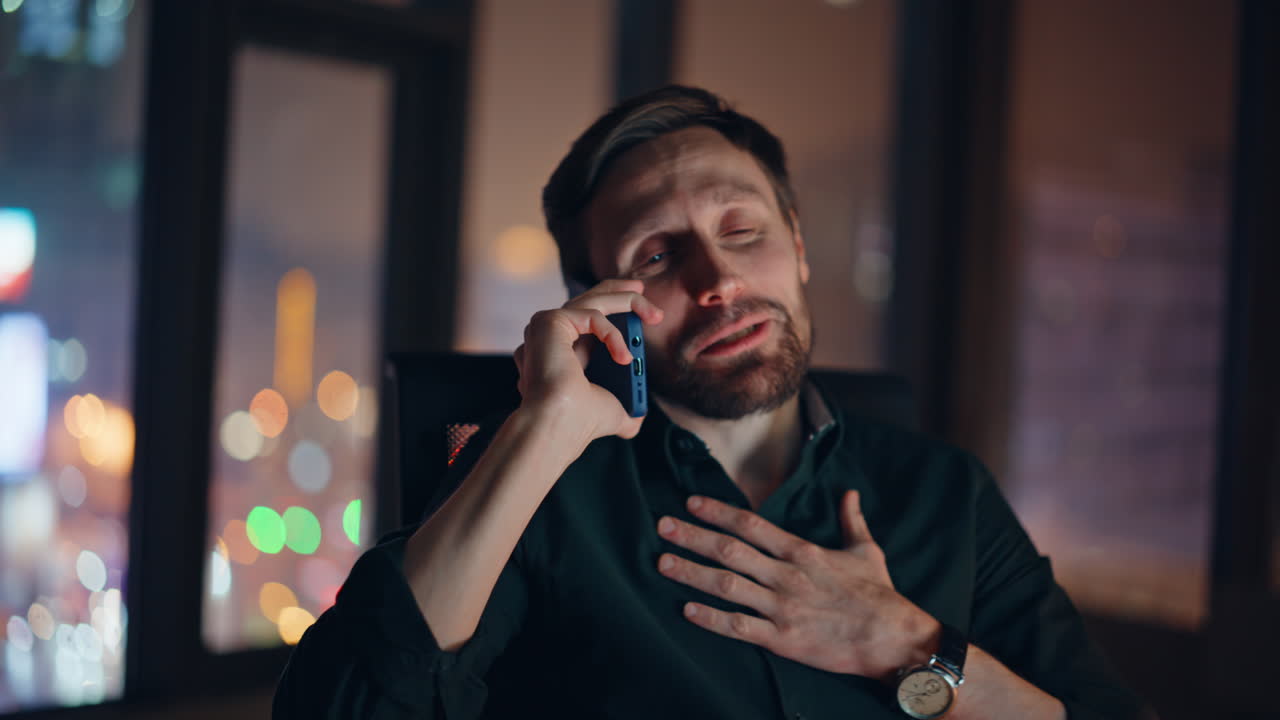 Glad medarbejder nyder telefonsamtale på natkontoret glad tæt på