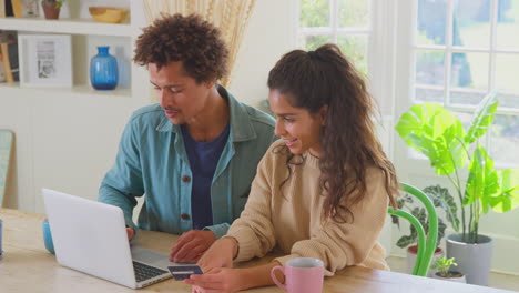 couple with credit card at home use laptop to make purchase for independent business