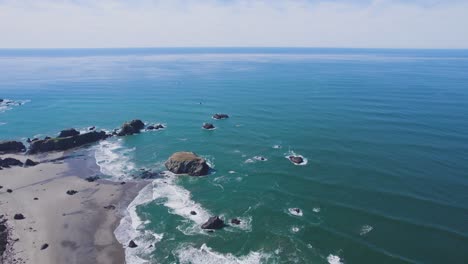 Epic-wide-overview-of-Bandon-Oregon-coastline-with-rolling-waves-under-blue-sky