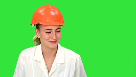joven ingeniera de construcción sonriendo mientras tiene una videoconferencia con una computadora portátil en una pantalla verde, clave de croma