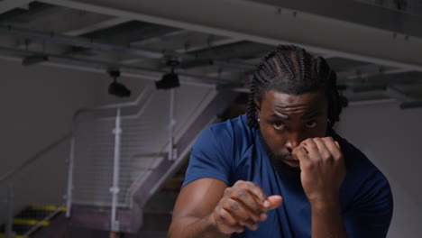 portrait of male athlete or boxer training in gym sparring and warming up preparing for sports event or fight