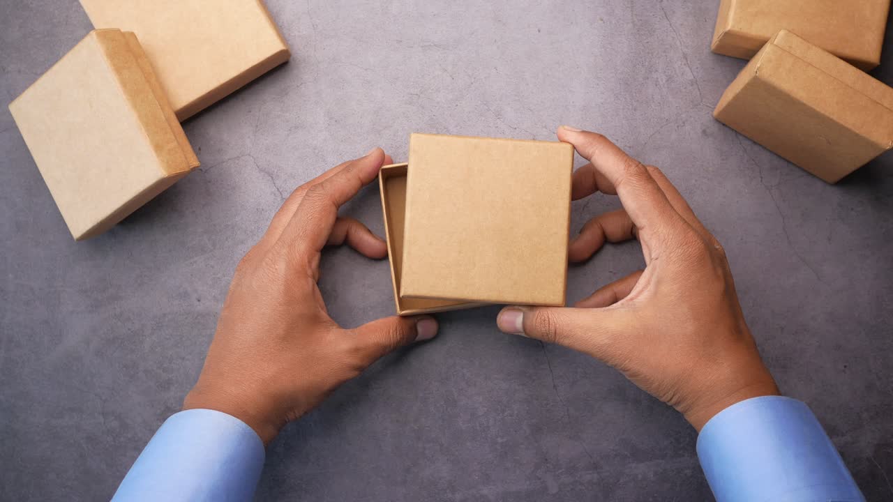 Hands holding an open cardboard box