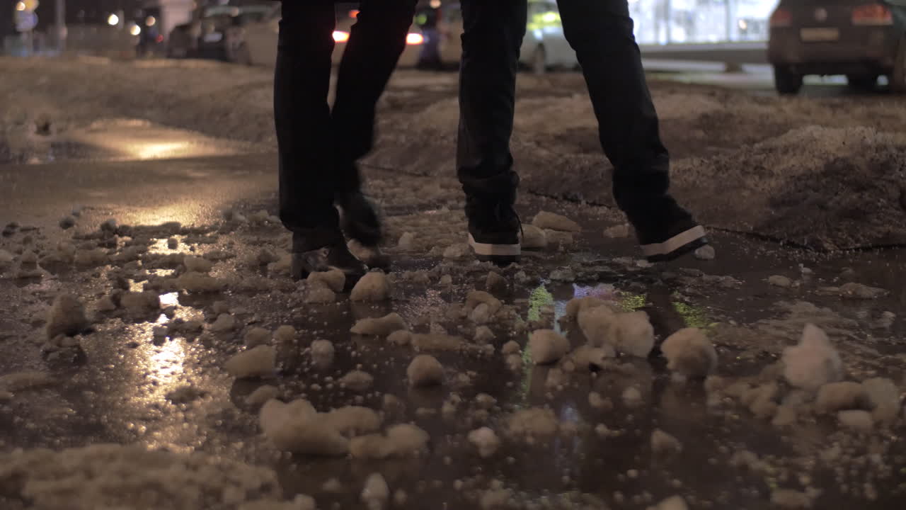 dos personas caminando en la ciudad de invierno por la noche