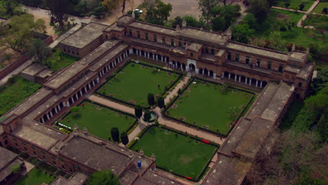 old beautiful educations institute aerial zoom out view surrounded by green trees and parks, students are in the institute