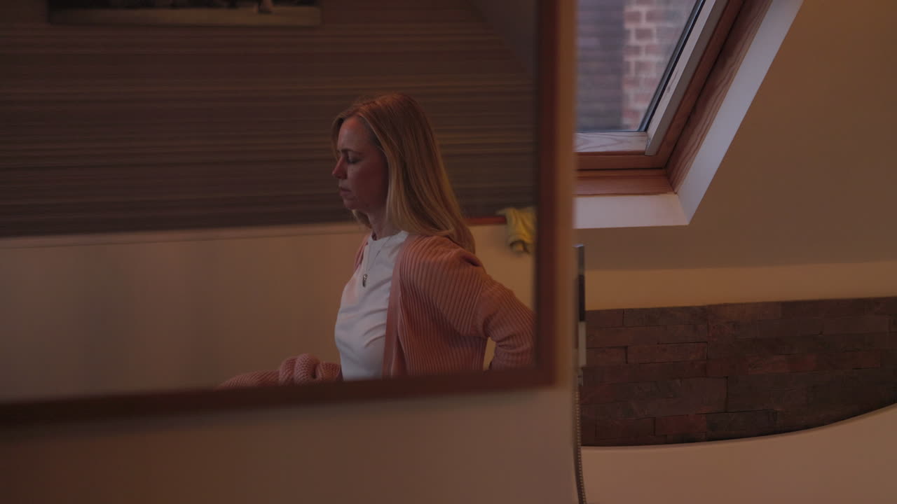 Woman reflected in a mirror in a bedroom