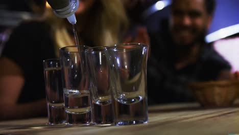 bartender tequila in shot glasses in bar