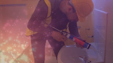 animation of glowing lights over caucasian man working using silicone in bathroom