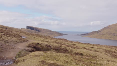 Panorámica-Ancha-A-La-Derecha-Del-Lago-Sobre-El-Océano-Y-El-Acantilado-En-Las-Islas-Feroe