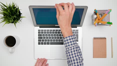 a man's hands typing on the laptop