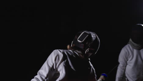 a fencer in action, with a white uniform and a mask, holding a sword