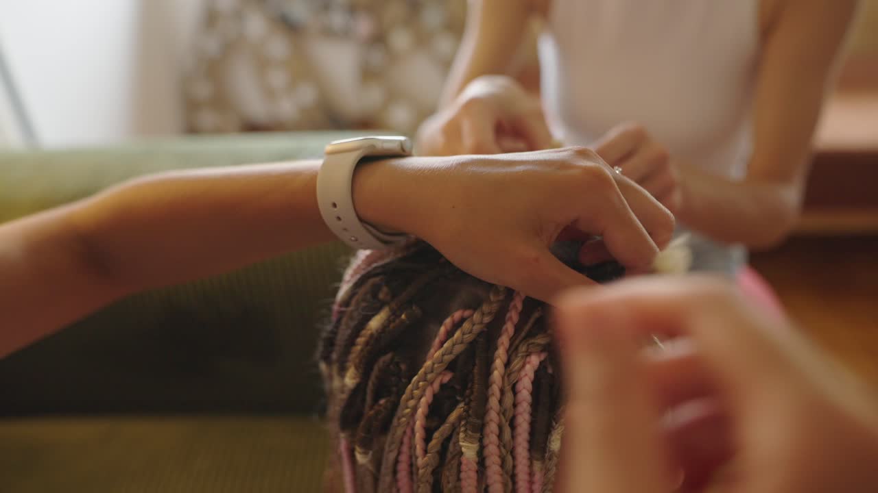 Close-up of hands braiding hair