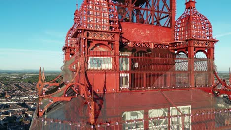 aerial drone flight circling around the top of blackpool tower showing the inside of the tower and its glass windows and steel structures