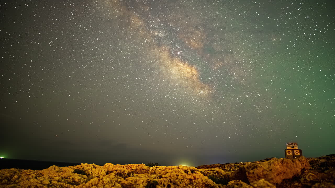 바위 가 있는 해안선 위 를 지나가는 은하계 와 함께 별 이 있는 하늘