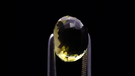 natural yellow citrine in the tweezer on the turning table