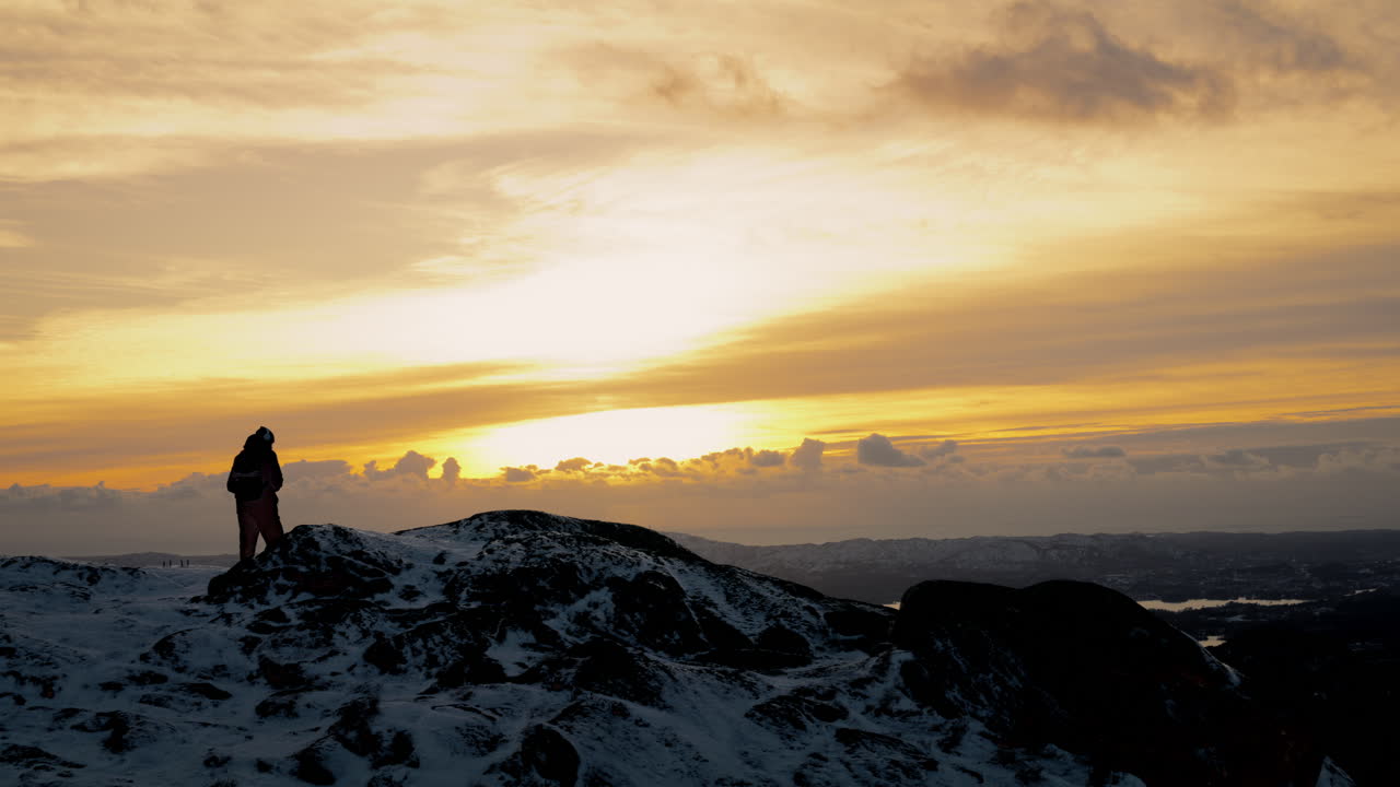 toma estática de una caminata tomando una foto y luego sentándose en la parte superior de lovstakken