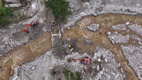 aerial view captures jcb machines actively working to manage flood disaster in ruined village surrounded by a huge river and forest urgency of environmental protection and relief efforts