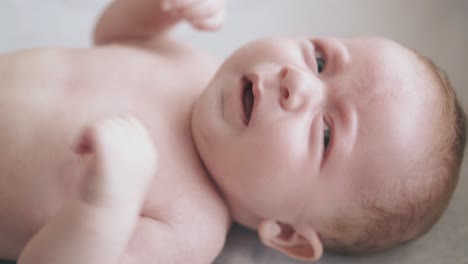 ein säugling mit flauschigen wangen liegt auf dem umkleidetafel des babys