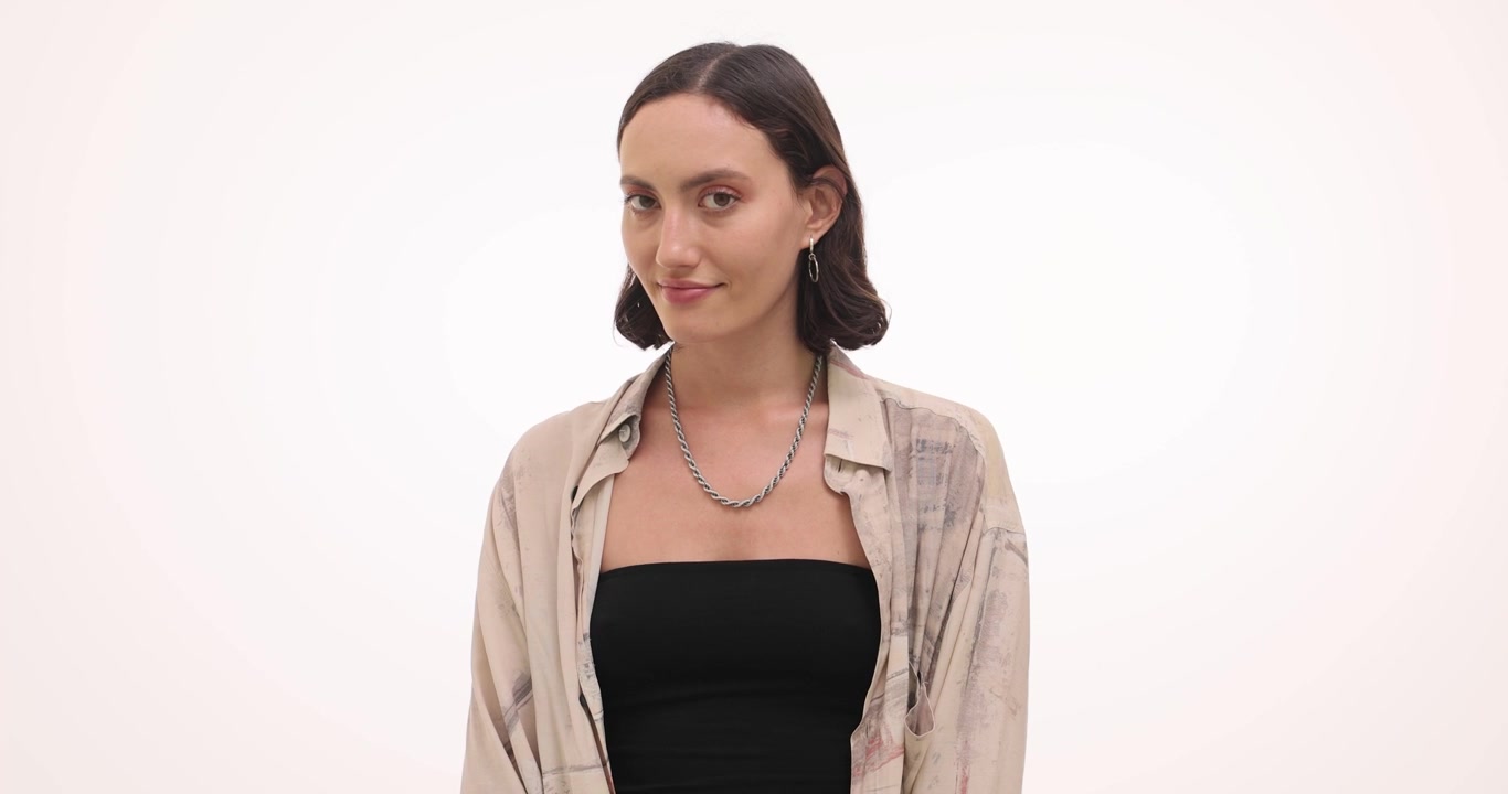 Donna guarda con espressione timida e malinconica.
