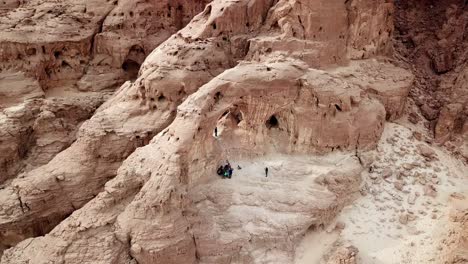 group of tourists listen to a guide at the arches in the dry timna park in the red canyon in the negev desert in southern israel