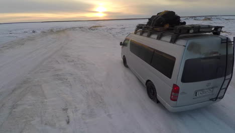 aerial as a truck drives across frozen tundra in the russian arctic in siberia