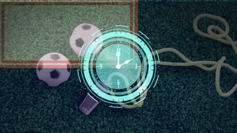 Animación-De-Un-Reloj-De-Neón-Sobre-Un-Primer-Plano-De-Pelotas-De-Fútbol-En-Miniatura-Y-Un-Silbato-En-Un-Campo-De-Hierba.