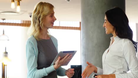 Women-interacting-with-each-other-while-using-digital-tablet