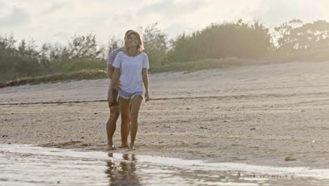 pareja teniendo un romántico paseo por la playa al atardecer
