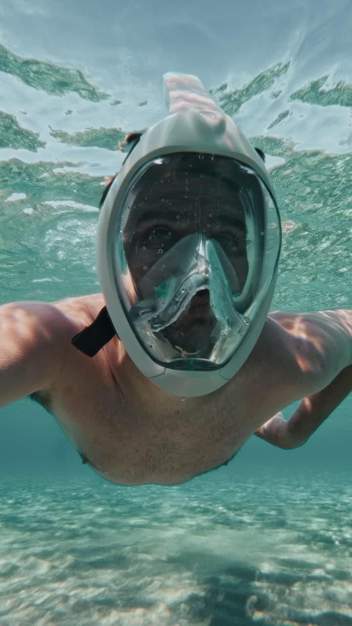 Vertical View Of A Man With A Snorkeling Mask Under Clear Water. Close-up Shot