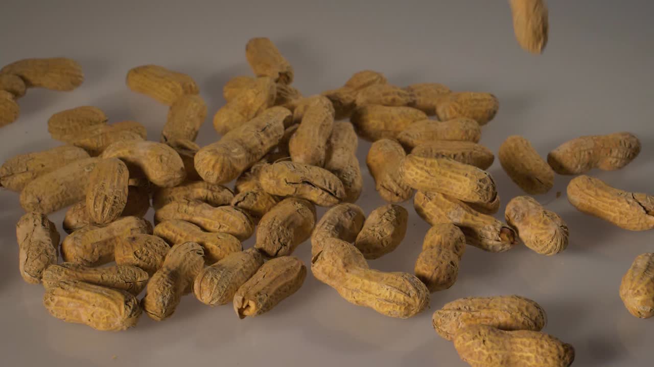 Peanuts in shells fall in slow motion