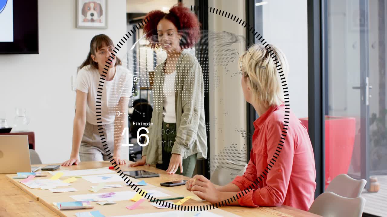 Three women working at table, tablet showing, HUD overlaying table while finalizing business plan